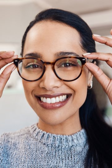 Shot of a young woman buying a new pair of glasses at an optometrist store