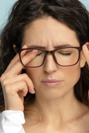 Sleepy business woman in glasses rubbing eyes suffering from ocular diseases, eye strain. Fatigue.