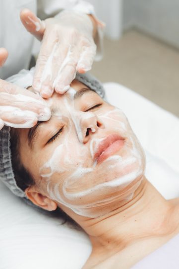 the cosmetologist cleanses the skin with foam.