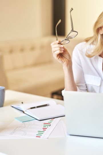 Tired mature businesswoman took off her glasses, massaging nose bridge, suffering from dry eyes