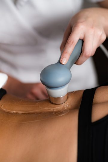 Ultrasound in Physical Therapy. Therapist Using Ultrasound Applicator on a Patient’s Lower Back